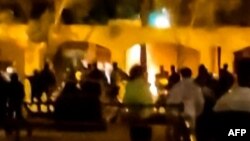 This image grab from a UGC video posted on Nov. 17, 2022, reportedly shows Iranian protesters starting a fire at the family home of the founder of the Islamic republic Ayatollah Ruhollah Khomeini, now a museum, in the central Iranian city of Khomein. (AFP