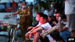 Family members of victims of the An Phu karaoke bar fire wait outside the Thuan An General hospital in Binh Duong province, north of Ho Chi Minh City, Vietnam, Sept. 7, 2022.