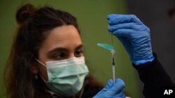 FILE - A medical staff member prepares a Pfizer vaccine during a COVID-19 vaccination campaign in Pamplona, northern Spain, on March 16, 2021. 