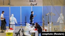 资料照：抵达上海虹桥国际机场的旅客在接受新冠核酸检测。 （2022年10月12日）