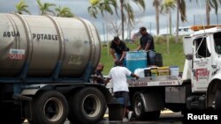 Local residents fill up cans with water in Bayamon following damages caused by Hurricane Maria in Carolina, Puerto Rico, Sept. 30, 2017.