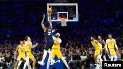  Joel Embiid (21) de Philadelphie effectue un tir devant l'attaquant Anthony Davis (3) des Lakers, USA, le 27 novembre 2023.