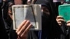 Seorang pengunjuk rasa mengangkat Al-Qur'an saat melakukan protes terkait pembakaran Al-Qur'an di Swedia, di depan Kedutaan Besar Swedia di Teheran, Iran, Jumat, 30 Juni 2023. (Foto: AP)