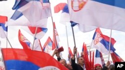 Para pendukung pemimpin separatis Serbia Bosnia Milorad Dodik mengibarkan bendera Serbia dalam aksi protes di Banja Luka, pada 18 April 2024. (Foto: AP/Radivoje Pavicic)
