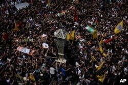 Mourners carry the bodies of Palestinian men, some draped in the flags of the Islamic Jihad militant group and Hamas, during their funeral, in the Jenin refugee camp, West Bank, July 5, 2023.