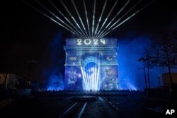 A light show is projected on the Arc de Triomphe during New Year celebrations on the Champs Elysees in Paris, France, Jan. 1, 2024.