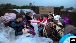 Ethnic Armenians from Nagorno-Karabakh sit in a truck on their way to Kornidzor in Syunik region, Armenia, Sept. 25, 2023. 