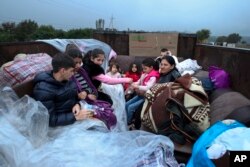 FILE - Ethnic Armenians from Nagorno-Karabakh sit in a truck on their way to Kornidzor in Syunik region, Armenia, Sept. 25, 2023.