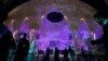 People walk near a lit up Al Wasl Dome at Expo City at the COP28 U.N. Climate Summit, Dubai, United Arab Emirates, Dec. 1, 2023.