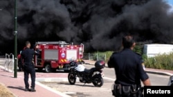 Israeli policemen stand next to smoke from a fire following incoming rockets from Lebanon to Israel in Bezet, northern Israel, April 6, 2023.
