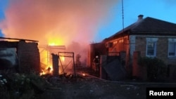 Firefighters work at a house ablaze following a shelling that, according to the regional governor, was done by Ukrainian forces, in the village of Sobolevka, Belgorod region, Russia, in this handout image released June 2, 2023.