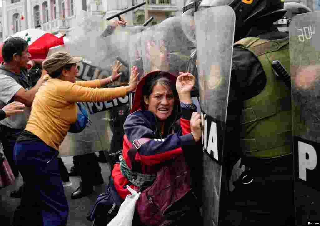 Anti-government demonstrators clash with police officers during a national protest to demand the resignation of Peruvian President Dina Boluarte, in Lima, July 29, 2023.