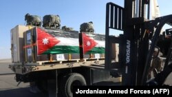 This handout photo released by the Jordanian armed forces media office on Feb. 21, 2024, shows boxes of humanitarian aid provided by Jordan and Britain being transported to a military plane and slated for airdrops over the Gaza Strip. (Photo by Jordanian Armed Forces/AFP)