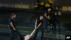 An injured demonstrator is dragged by police to be detained during a protest against plans by Netanyahu's government to overhaul the judicial system, in Tel Aviv, Israel, Monday, July 24, 2023. 