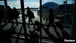 FILE - Passengers make their way through the terminal at Washington Dulles International Airport in Dulles, Virginia, Nov. 22, 2023.