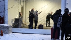 资料照片：加拿大皇家骑警在魁北克省一个非正规入境者接收中心搜查抵达的移民。（2022年1月12日）