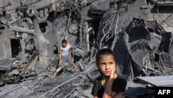 A girl looks on as she stands by the rubble outside a building that was hit by Israeli bombardment in Rafah in the southern Gaza Strip on Oct. 31, 2023.