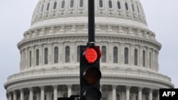 FILE - A stoplight is seen in front of the dome of the US Capitol as a government shutdown looms in Washington on Sept. 28, 2023.