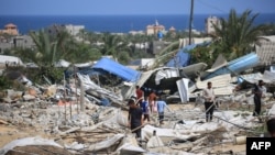 People look for salvageable items following an Israeli raid in al-Mawasi area of Rafah on the southern Gaza Strip, June 29, 2024.