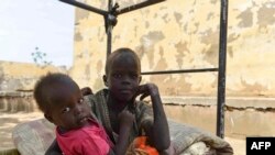 Des enfants déplacés qui ont fui les violences en cours de deux généraux soudanais rivaux, reposent sur un lit dans la cour de l'université d'Al-Jazira, transformée en abri de fortune, à al-Hasahisa, au sud de Khartoum, le 8 juillet 2023. (Photo par AFP)
