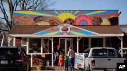 A family arrives at Leavitt's Country Bakery, April 13, 2023, in Conway, New Hampshire. The large painting of pastries over the bakery is the center of a legal battle pitting a zoning ordinance against free speech rights.