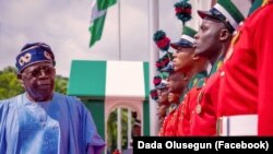 Shugaban Najeriya Bola Ahmed Tinubu yana duba jami'an tsaro a bikin ranar dimokuradiyya a fadarsa