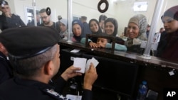 فلسطینی‌های دارای تابعیت‌ دوگانه برای عبور از گذرگاه مرزی رفح در نوار غزه با مامور مصری صحبت می‌کنند ۱۱ آبان ۱۴۰۲. (عکس آسوشیتدپرس/ حاتم علی)