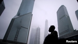 资料照：一名男子站在上海浦东金融区的街道上。