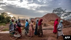 wanawake wachimba migodi wa tanzania wakitembea pamoja wakati wa magharibi Mei 262022. Picha na LUIS TATO / AFP