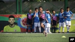Young soccer players train at the Club Bayer soccer school that was founded by Luis Manuel Diaz, father of the Colombian player and Liverpool striker Luis Diaz, featured on the wall at left, in Barrancas, Colombia, Nov. 8, 2023.