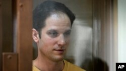 Reporter Wall Street Journal Evan Gershkovich berdiri di dalam sangkar kaca di ruang sidang Pengadilan Kota Moskow, di Moskow, Rusia, Selasa, 19 September 2023. (AP/Dmitry Serebryakov)