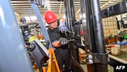 中国山东省青州市的一个铲车工厂的工人在装配铲车。（2023年10月18日）