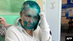 This handout picture released on July 4, 2023 by Sergei Babinets, the head of the Crew Against Torture, shows Russian investigative journalist Elena Milashina speaking on a mobile phone at a hospital in the Chechen capital Grozny. Green dye is used to target Kremlin critics.