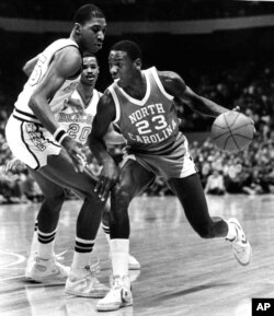 In this Feb. 17, 1982, file photo, North Carolina's Michael Jordan (23) drives around the defense of Wake Forest's Anthony Teachey, left, and Danny Young (20) at the Greensboro Coliseum in Greensboro, N.C. (AP Photo/Bob Jordan, File)