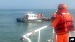 In this handout photograph provided by Taiwan Coast Guard Administration, Taiwanese coast guards inspect a vessel that capsized during a chase off the coast of Kinmen archipelago in Taiwan, Feb. 14, 2024. 