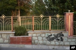 A graffiti against the government which is painted over in black is seen on the wall at a park in Tehran, Iran, Sept. 11, 2023.