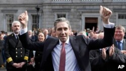 The new Prime Minister of Ireland, Simon Harris, gestures as he is applauded by fellow lawmakers outside Leinster House, in Dublin, Ireland, April 9, 2024. 