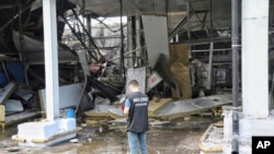 우크라이나 전쟁범죄 조사 당국자가 지난 6월 오데사 로켓 공격 현장을 살피고 있다. (자료사진)