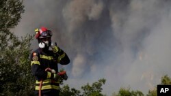 A firefighter from Romania tries to stop the fire at the village of Agia Sotira, Greece, near Athens, July 18, 2023.