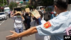 FILE - A volunteer guides local residents taking shelter during the Wan An Air Raid Drill, a civilian air-raid held on the day of the annual Han Kuang military exercise, in Taipei on July 24, 2023.