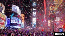 People watch confetti flying around after the clock strikes midnight during New Year celebrations at Times Square, in New York City, Jan. 1, 2024. 
