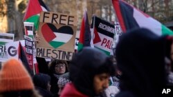 Protester hold flags and placards as they take part in a pro-Palestinian demonstration as they wend their way along Whitehall in London, Nov. 25, 2023.