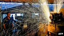 中国山东省青州市一个汽车轮辋工厂的工人正在生产线上工作。（2024年6月17日）