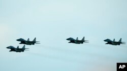 FILE - Slovak Air Force MiG-29s fly over an airport during an airshow in Malacky, Slovakia, on Aug. 27, 2022. 
