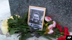 Un portrait du chef de l'opposition russe Alexei Navalny que Lyudmila Navalnaya, sa mère, a placé pour rendre hommage à son fils au mémorial aux victimes de la répression politique, à Salekhard, au nord-est de Moscou, en Russie, le 20 février 2024. (Photo AP)