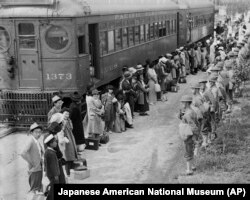 FILE - In this photo provided by the National Archives, Japanese Americans from San Pedro, Calif., arrive at the Santa Anita Assembly Center in Arcadia, California, April 5, 1942.