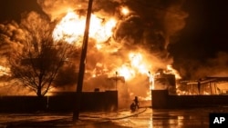 Firefighters extinguish a fire after a Russian attack on a residential neighborhood in Kharkiv, Ukraine, Feb. 10, 2024. 