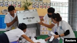 Election officials count ballots at a polling station on the day of Cambodia's general election, in Phnom Penh, Cambodia, July 23, 2023.

