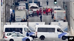 FILE - In this March 22, 2016, photo, police and rescue teams are pictured outside the metro station Maelbeek in Brussels. The trial of those accused in the bombings at the metro and the city's airport began in earnest this week.