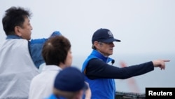 Rafael Mariano Grossi mendengarkan penjelasan dari Tomoaki Kobayakawa, Presiden Tokyo Electric Power Co., saat mengunjungi pembangkit listrik tenaga nuklir Fukushima yang rusak di Futaba, Jepang, 5 Juli 2023. (Hiro Komae/Pool via Reuters)